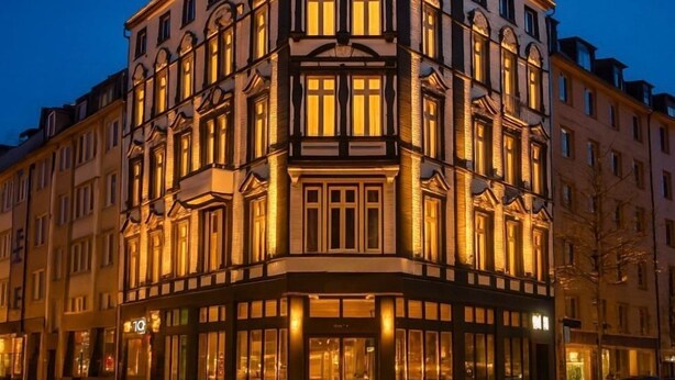 A multi-story hotel with a prominent entrance and illuminated signage. - La Plaza24 (Düsseldorf)