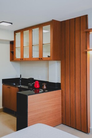 Frigorífico pequeño, placa de cocina y utensilios de cocina