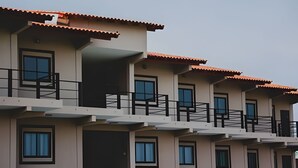 A multi-story building with balconies, large windows, and a flat roof. - Loft completo e climatizado (Cuiabá)