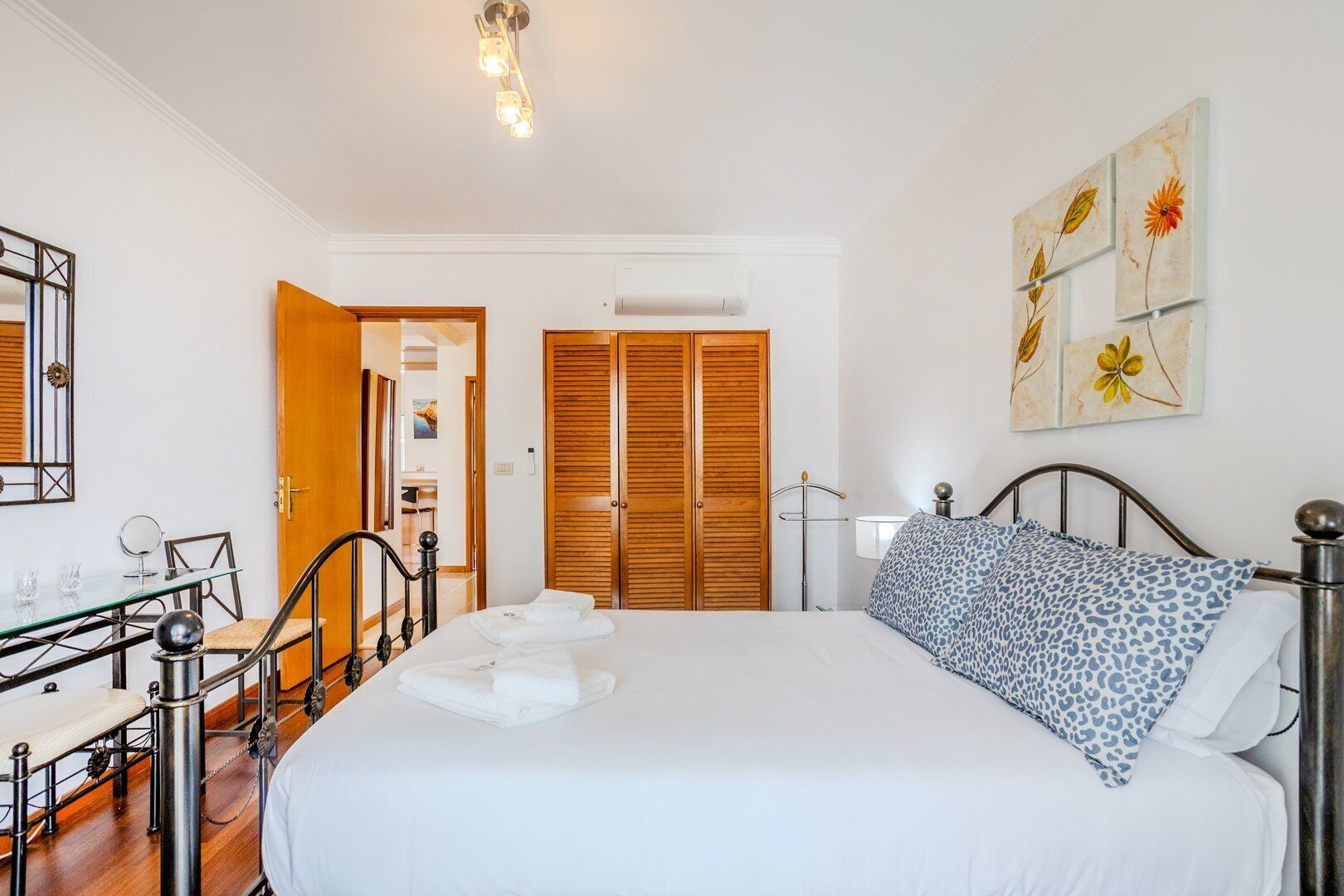 Una camera da letto con un letto, un comodino, una lampada e un quadro appeso al muro.