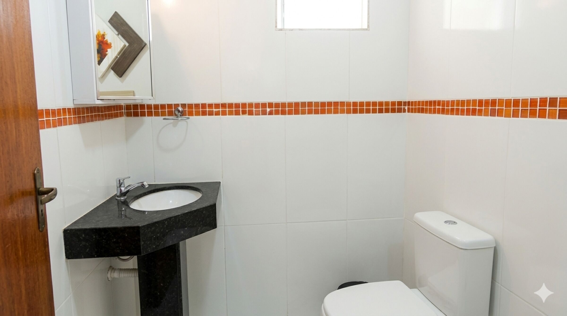A bathroom with a white toilet, a black sink, and a mirror above it.