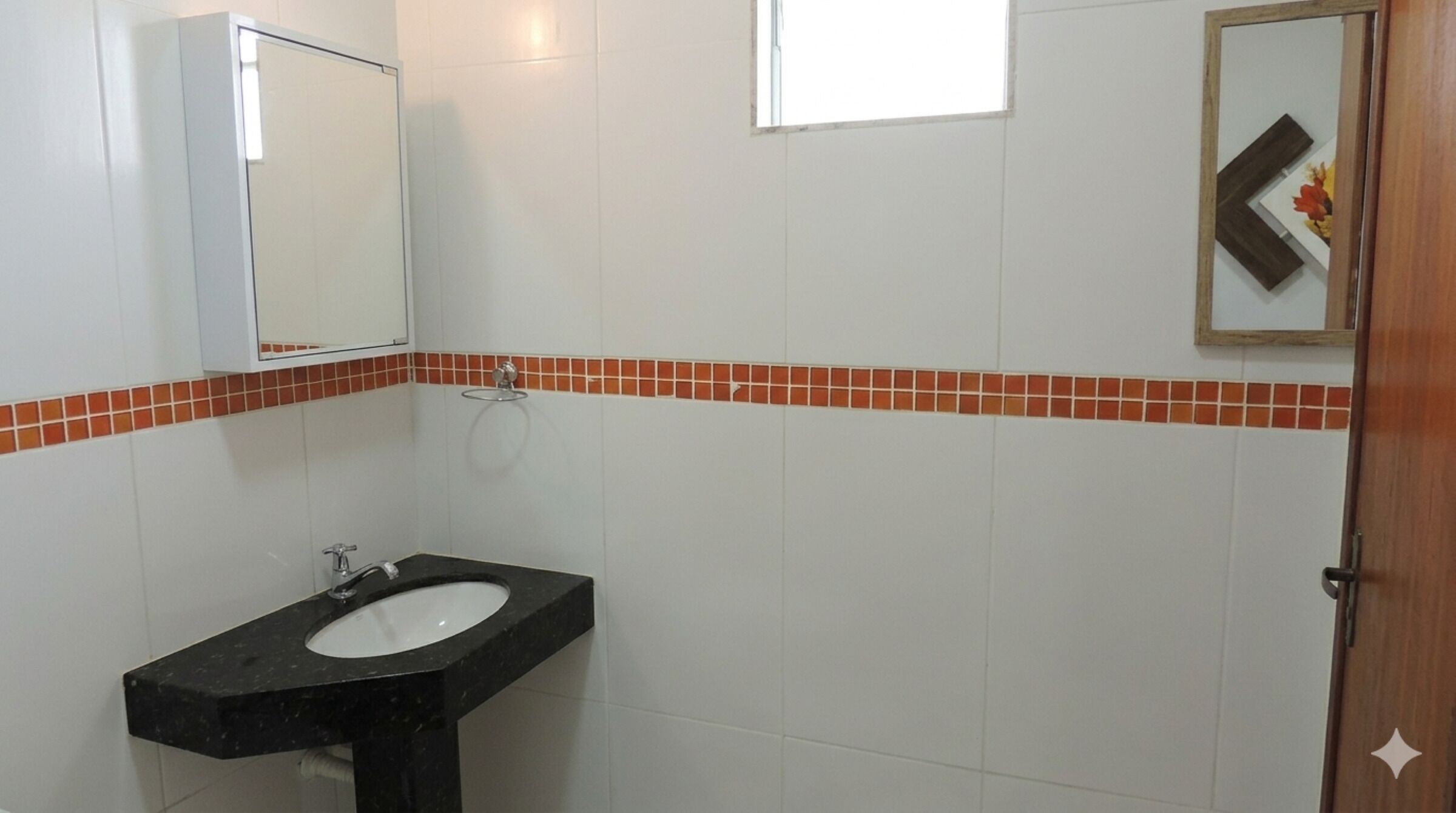A bathroom with a black sink, white tiles, and a mirror.