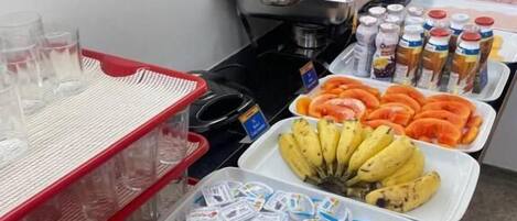Una mesa de buffet con diversos alimentos, como frutas, productos lácteos y salsas.