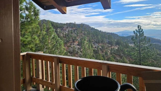 A wooden deck with a view of a mountainous landscape.