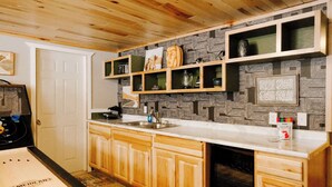 A kitchen with wooden cabinets, a white countertop, and a patterned backsplash. - Winter Ski Trip Getaway (Bessemer)