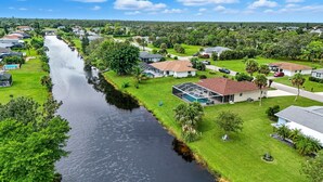 A residential area with houses along a river, a swimming pool, and a gazebo. - Casa Mar Van Beautiful newly renovated Home on Canal Heated Pool w/Spa andLanai (Rotonda West)