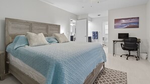 A bedroom with a large bed, a desk with a chair, and a painting on the wall. - Casa Mar Van Beautiful newly renovated Home on Canal Heated Pool w/Spa andLanai (Rotonda West)