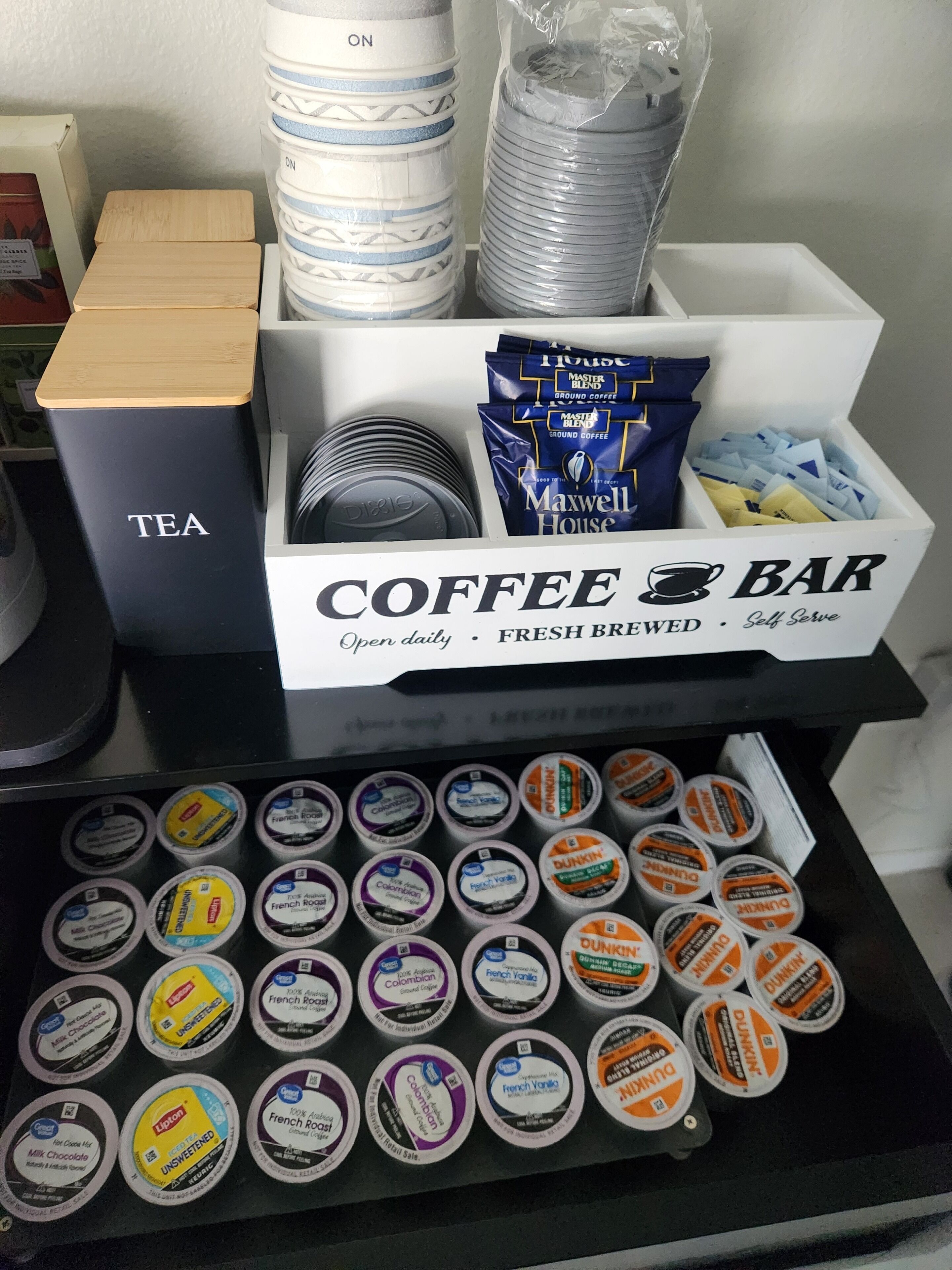 A coffee bar setup with tea and coffee options, including Maxwell House and Dunkin' Donuts branded products.