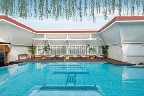 A swimming pool with a covered seating area, potted plants, and a clear blue sky. - The Hermitage, a Tribute Portfolio Hotel, Jakarta (Central Jakarta)