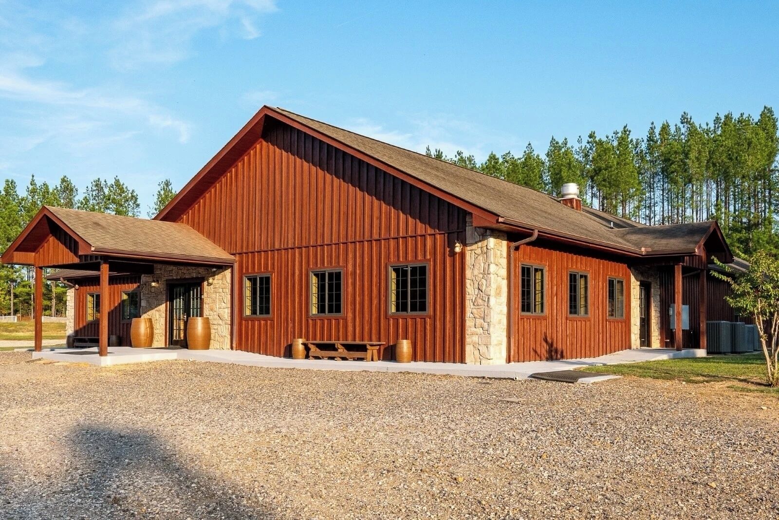 Ein großes, rustikales Gebäude mit Steinunterbau und Holzfassade, mit mehreren Fenstern und einer Veranda.