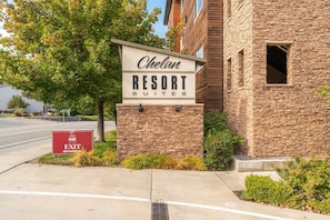 Une enseigne pour le complexe hôtelier Chelan Resort Suites, avec une façade en pierre et une signalétique claire indiquant la sortie.