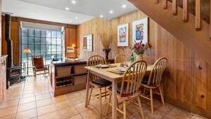 A wooden interior with a dining table, chairs, and a fireplace. - Black Butte Ranch Country House 62 (Sisters)