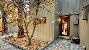A modern building with a wooden exterior, a wooden deck, and a tree in the center. - Black Butte Ranch Country House 62 (Sisters)