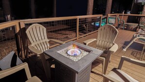 Eine Terrassengrundstück mit Feuerstelle, Sitzgelegenheiten und Poolbereich.