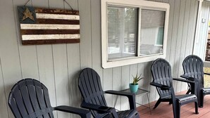 A porch with four Adirondack chairs, a small table, and a potted plant. - Cute, Cozy, Peaceful Getaway, Fenced Yard, Big Bear's Lazy Neighborhood with Soaring Pines (Sugarloaf)
