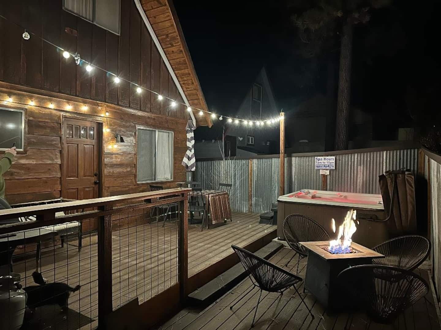 A wooden deck with outdoor seating and a fire pit.