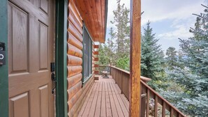 A wooden cabin with a deck, a door, and a window. - Peaceful Rustic Escape, Cool Deck with Firepit Table - No Better Escape than Our Private Lot - 3BR w/Game Loft, Pac Man tabletop games console! (Big Bear)