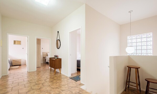 A spacious hallway with a wooden floor, white walls, and a wooden cabinet with a mirror. There is a window with blinds on the right side. - 5 Bedroom House 200 m From the Beach Cmm0043 (Penha)