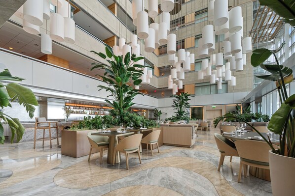 A spacious lobby with high ceilings, modern lighting fixtures, and multiple seating areas.