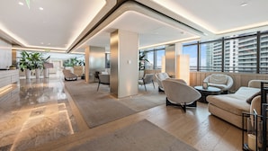 A spacious lobby with a modern design, featuring a reception desk, seating area, and large windows offering views of the city. - Brickell Sea View 2BR Free Parking by Palermo Home (Miami)