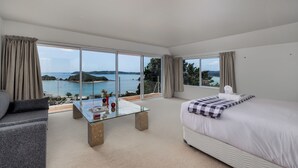 A modern hotel room with a large window offering a view of a body of water and distant land. - Seabreeze Sanctuary - Paihia Holiday Home (Paihia)