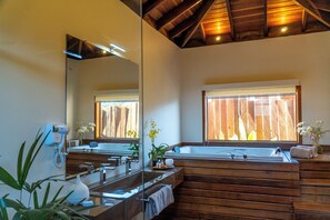 Une salle de bain moderne avec un meuble-lavabo en bois, un grand miroir et une baignoire.