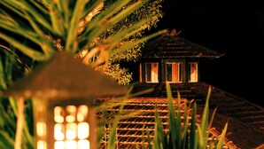 A traditional Japanese-style building at night with a lit lantern in the foreground. - Atiaia Jungle River Retreat (Bocaina de Minas)