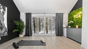 A modern room with a large window, a green wall, and yoga mats on the floor. - Luxury mini-chalets to disconnect for two with a private spa nestled in the hear (VAL DES LACS)