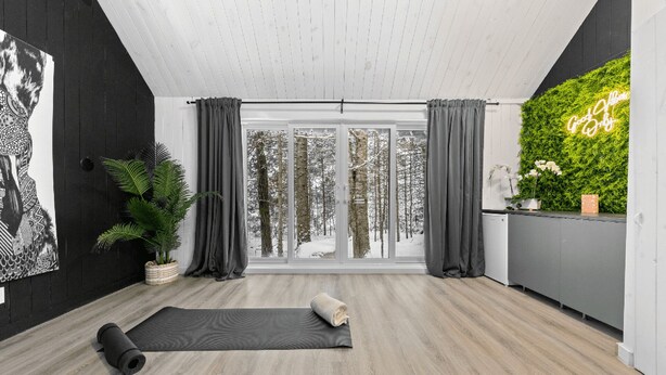 A modern living room with a large window, a green wall, and a yoga mat. - Luxury mini-chalets to disconnect for two with a private spa nestled in the hear (VAL DES LACS)
