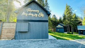 Una cabaña de madera rústica con un letrero de neón que dice "Promenade Nous done Le Roy".