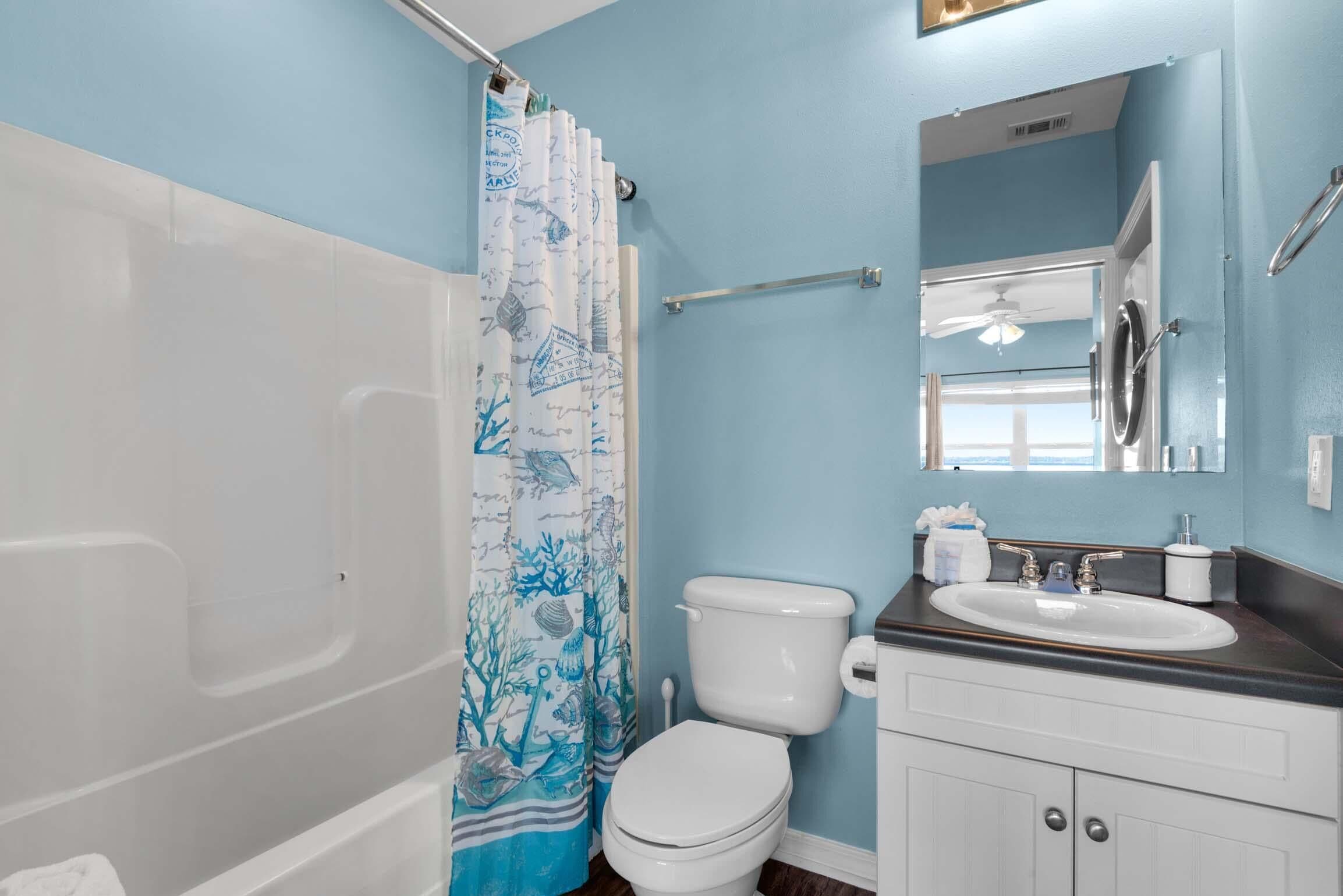 A bathroom with a bathtub, toilet, and sink.