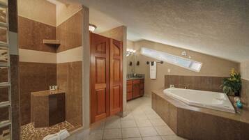 A modern bathroom with a large bathtub, a shower area, and a vanity with a sink.