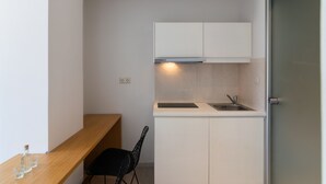 A compact kitchen with white cabinets, a stainless steel sink, and a wooden countertop. - Secret Nest 13 , studio,near the beach,Plakias (Plakias)