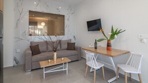 A modern living room with a sofa, a coffee table, and a dining table with chairs.