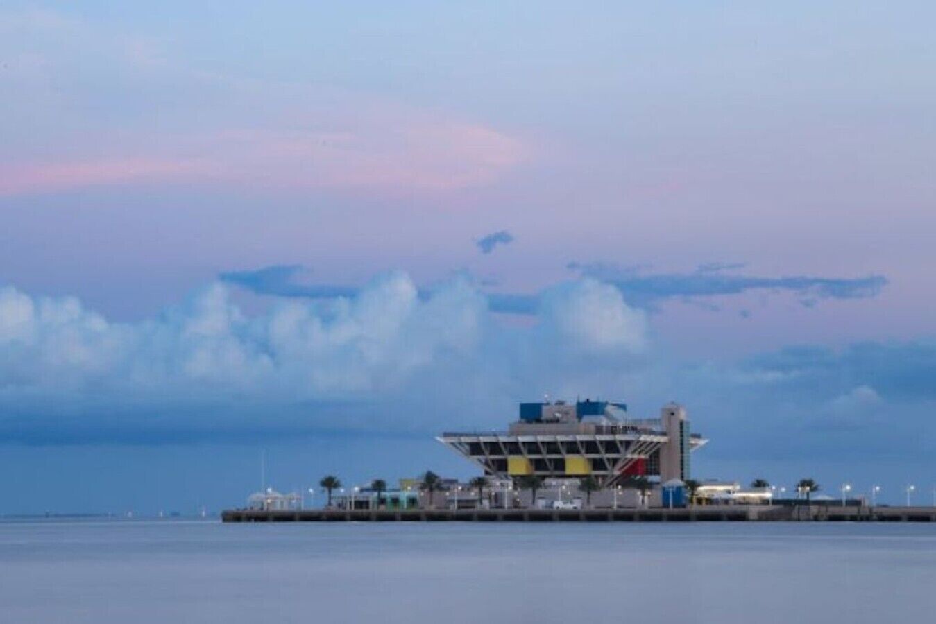Ein Gebäude am Wasser mit flachem Dach, einem großen offenen Raum und Blick auf das Wasser.