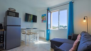 A compact living space with a kitchenette, a dining area, and a sofa.
