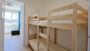 A bunk bed with a view of a balcony and a window.