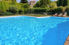 A clear blue swimming pool with a wooden deck and lounge chairs. - CASA-Martine vue sur mer et parking privé (Nice)