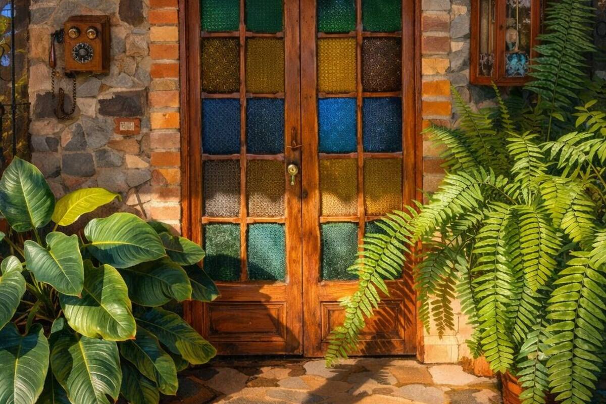 A wooden door with a glass panel, a stone wall with a herringbone pattern, and a stone-paved entrance.