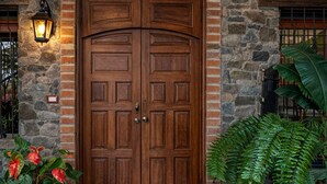 Puerta doble de madera con pared de piedra y un diseño de espiga arriba.