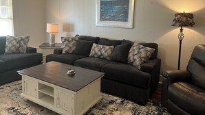 A living room with a dark brown sofa set, a white coffee table, and a patterned rug. - Quiet, Peaceful River property on 1.5 acres in Sterlington. (Sterlington)