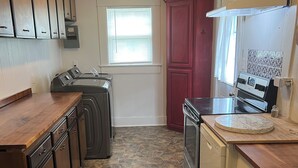 A kitchen with a stone tile floor, built-in appliances, and wooden cabinets. - Quiet, Peaceful River property on 1.5 acres in Sterlington. (Sterlington)