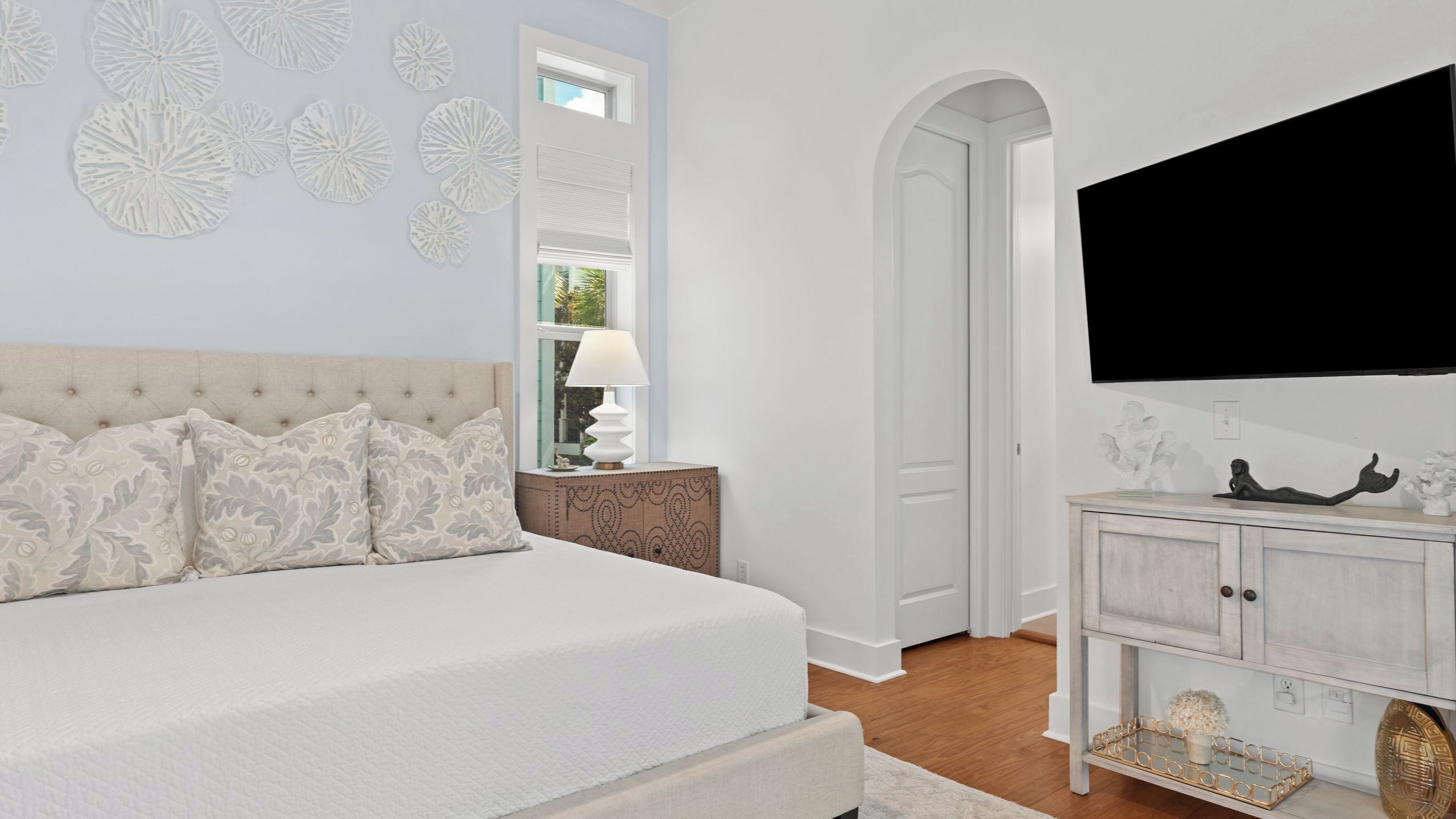 A bedroom with a bed, a TV, a nightstand, and a cabinet.