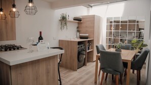 A modern kitchen with a central island, wooden cabinets, and pendant lighting.