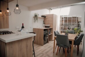 A modern kitchen with a central island, wooden cabinets, and pendant lighting. - Apartment in Rionegro, near JMC airport. (Rionegro)