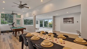 A spacious room with a pool table, dining table set for six, and a ceiling fan. - Casa Mattia 4BR Luxury Mountain Home (Suffern)