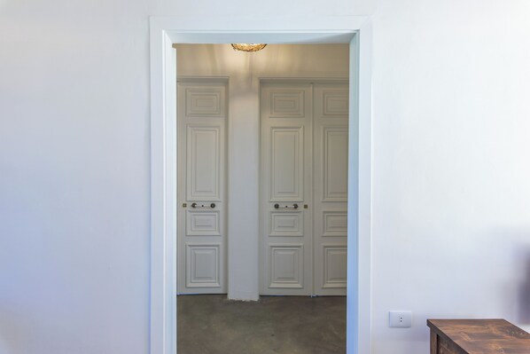 A hallway with double doors, a light fixture on the ceiling, and a power outlet on the wall. - LAuberge de Douma Full House in Batroun (Douma)