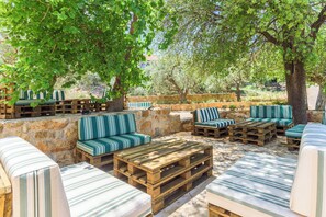 An outdoor seating area with wooden furniture and striped cushions. - LAuberge de Douma Full House in Batroun (Douma)