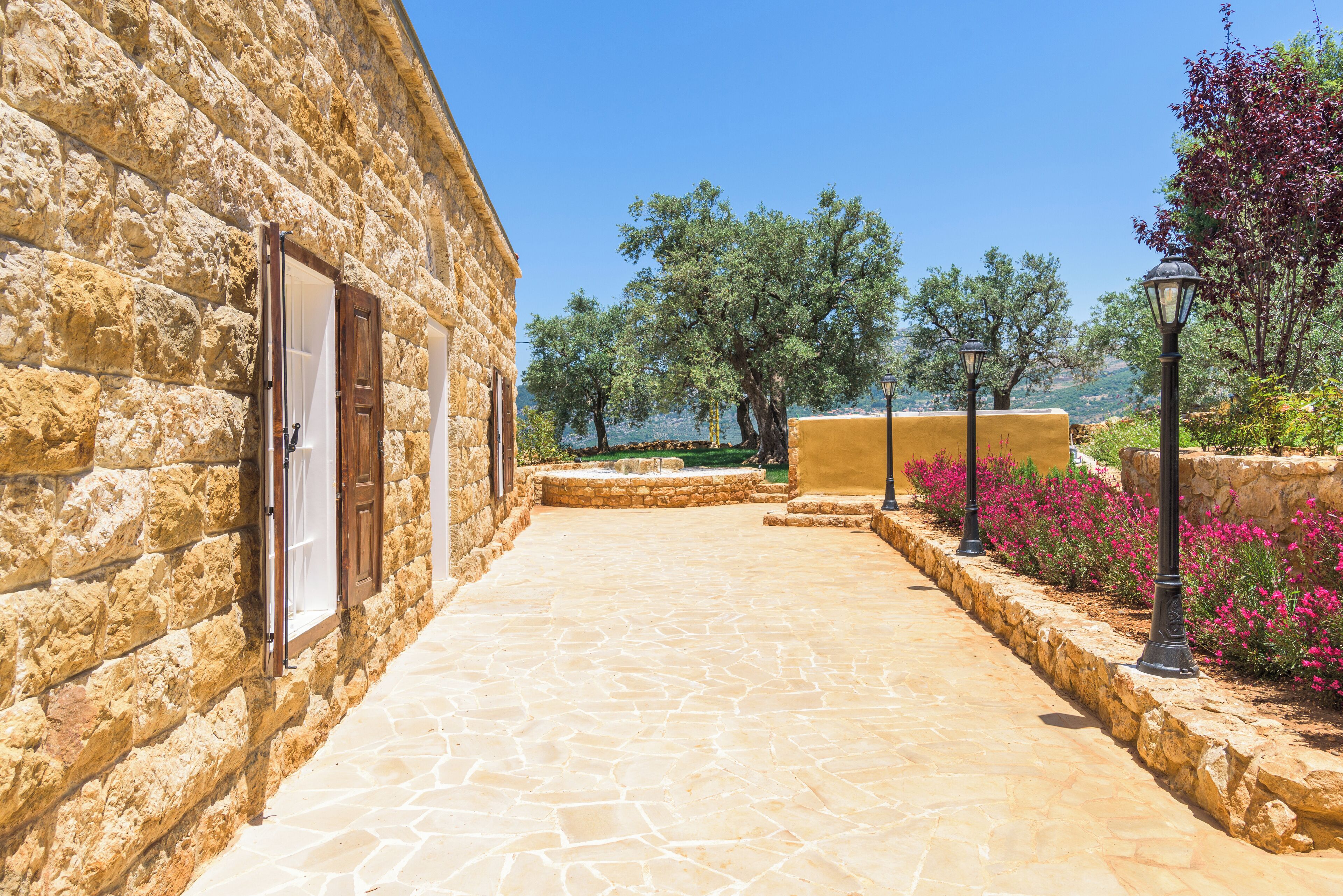 A stone building with a paved pathway leading to a scenic view.