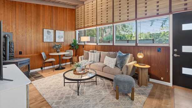 A cozy living room with a wooden ceiling, a sofa, a coffee table, and a dining area with a table and chairs. - Mid-Century Hideaway, Near Forest Park (Portland)